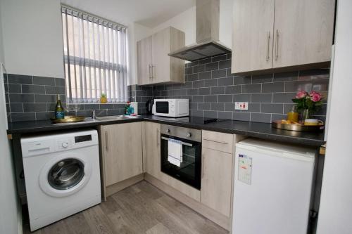 a kitchen with a washing machine and a microwave at Swan Studio One - Coventry in Coventry