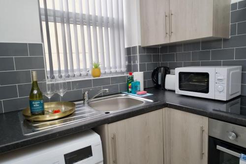 a kitchen with a sink and a microwave at Swan Studio One - Coventry in Coventry