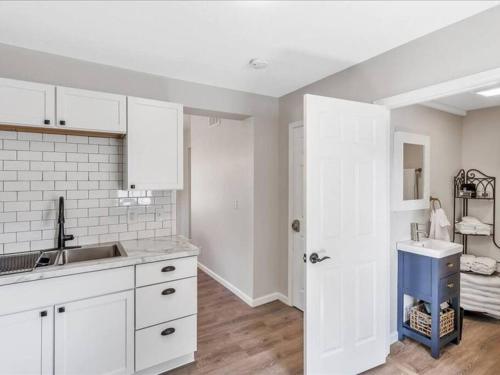 a kitchen with white cabinets and a sink at Pets, Big Groups Welcome: HotTub, Firepit, Grill in Bay City
