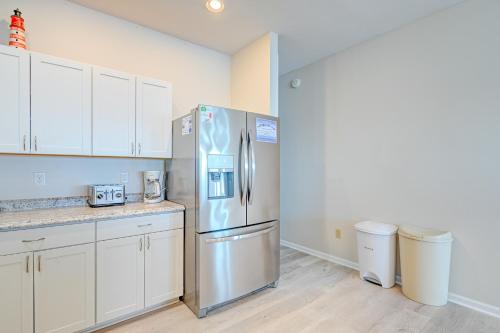 a kitchen with a stainless steel refrigerator and white cabinets at Seashore's Best in North Topsail Beach