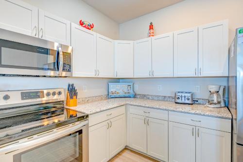 a kitchen with white cabinets and a stove top oven at Seashore's Best in North Topsail Beach