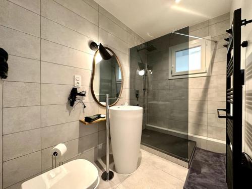 a bathroom with a toilet and a sink and a mirror at Le LUTZ in Nîmes