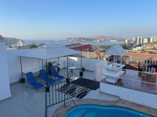 a balcony with chairs and a table and a pool at La Casa Blanca Departamento 1 piscina temperada in Coquimbo