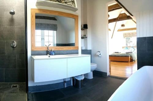 a bathroom with a white sink and a mirror at New Forest Cottage alongside Limewood Lyndhurst in Lyndhurst