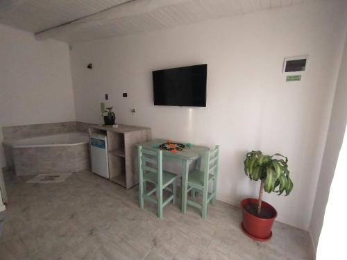 a bathroom with a tub and a table and a tv at Sierras Alojamiento in Mina Clavero