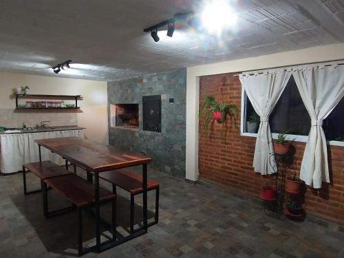 a living room with a table and a brick wall at Sierras Alojamiento in Mina Clavero