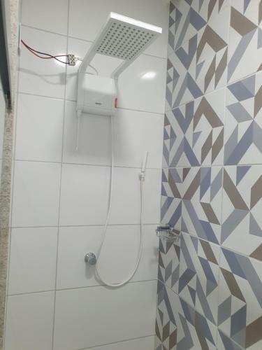 a shower with a shower head in a bathroom at SUÍTE PRAIA DE ITAPARICA in Vila Velha