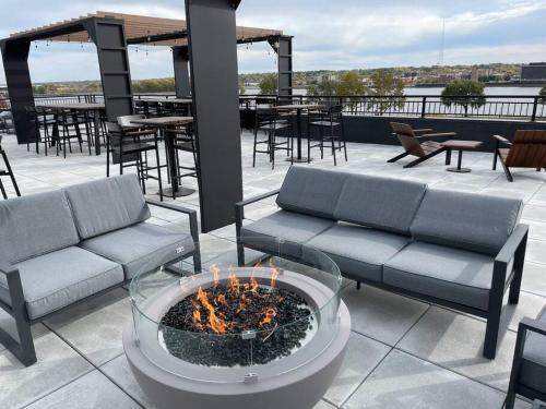 d'une terrasse avec un foyer extérieur, des tables et des chaises. dans l'établissement River Front Luxury Furnished Studio Downtown QC, à Davenport