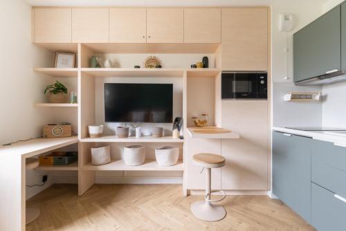 een keuken met een tv en een kruk in een kamer bij Studio refait à neuf avec Parking en Bord de Loire in Nantes