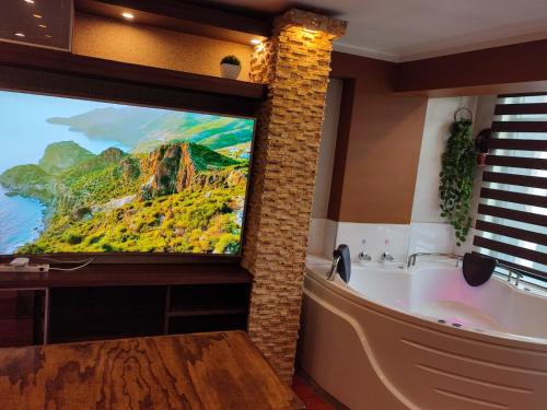 a bathroom with a bath tub and a painting on the wall at PULLMAN HOTEL in Juliaca