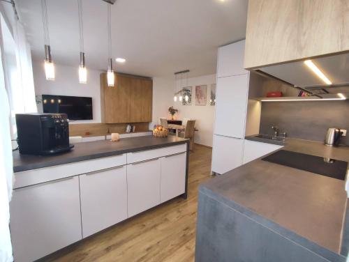 uma cozinha com armários brancos e electrodomésticos de aço inoxidável em Apartmán Pod zámkem em Mikulov