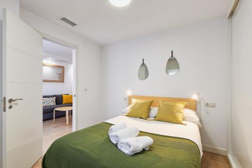 - une chambre avec un grand lit et des serviettes dans l'établissement Vecino de Picasso, à Malaga