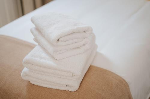 uma pilha de toalhas brancas sentadas numa mesa em 4 Esquinas Adeje Homes em Adeje