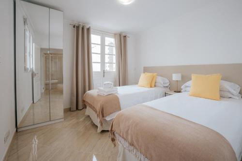 阿德赫的住宿－4 Esquinas Adeje Homes，一间卧室设有两张床和一个步入式淋浴间。