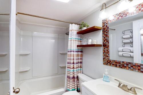 y baño con cortina de ducha y lavamanos. en Ocean Waye 226 en Ocean City