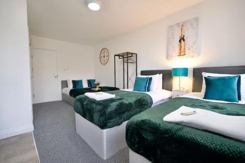 um quarto com duas camas com verde e branco em Swan Studio Three - Coventry em Coventry