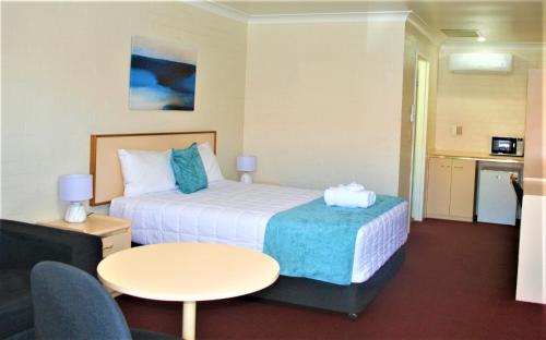 um quarto de hotel com uma cama e uma mesa em Club Motel Armidale em Armidale