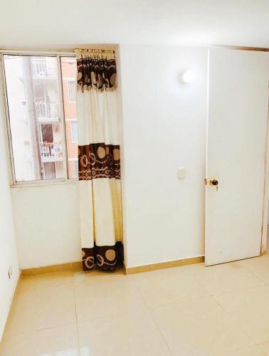 um quarto vazio com uma janela e uma cortina em APARTAMENTO AMOBLADO em Barranquilla