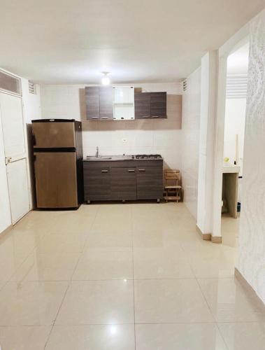 een keuken met een koelkast en kasten in een kamer bij APARTAMENTO AMOBLADO in Barranquilla
