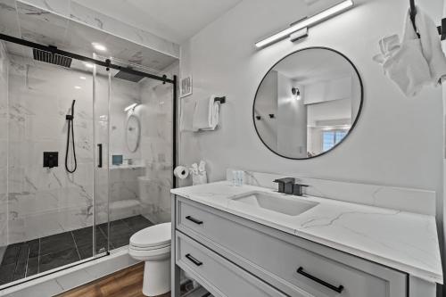 a white bathroom with a sink and a shower at The Summit 803 - Luxury Beach Resort Condo - Beachfront - Incredible Views - BEACH CHAIRS AND SUNSHADE Provided In Condo in Panama City Beach