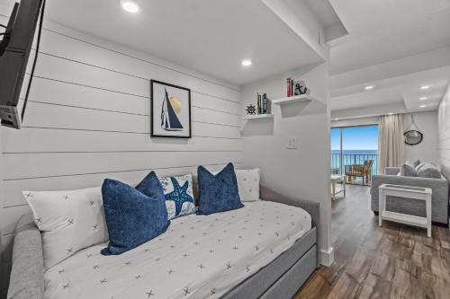 uma sala de estar com um sofá com almofadas azuis em The Summit 803 - Luxury Beach Resort Condo - Beachfront - Incredible Views - BEACH CHAIRS AND SUNSHADE Provided In Condo em Panama City Beach