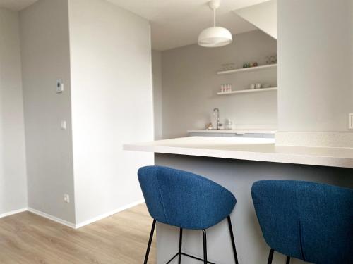 a kitchen with two blue chairs at a counter at Zentrale Ferienwohnung für bis zu 4 Personen in Bremerhaven
