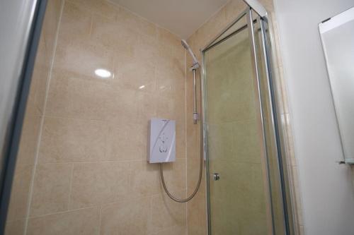 a bathroom with a shower with a clock on the wall at Swan Studio Four - Coventry in Coventry