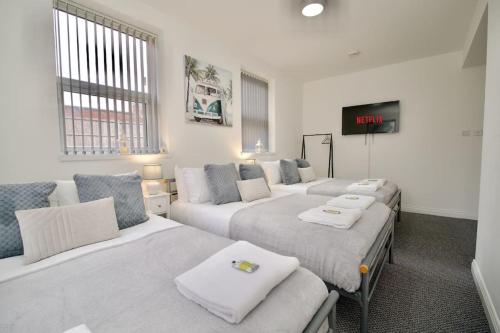 a hotel room with three beds and a tv at Swan Studio Four - Coventry in Coventry