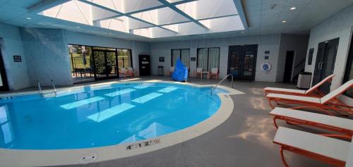 a large swimming pool in a building with chairs around it at Holiday Inn Staunton Conference Center by IHG in Staunton