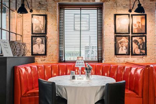 a dining room with a table and red leather booths at Best Western Hotel Herman Bang in Frederikshavn