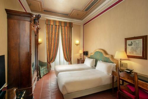 a hotel room with two beds and a window at Hotel Canada, BW Premier Collection in Rome