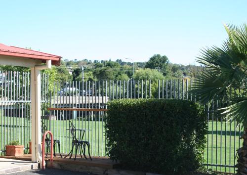 a bench sitting in front of a fence at Club Motel Armidale in Armidale
