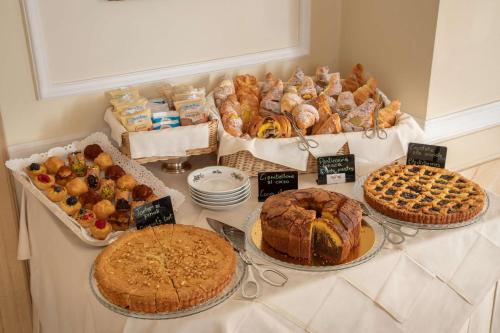 a table topped with different types of bread and pastries at Hotel Canada, BW Premier Collection in Rome