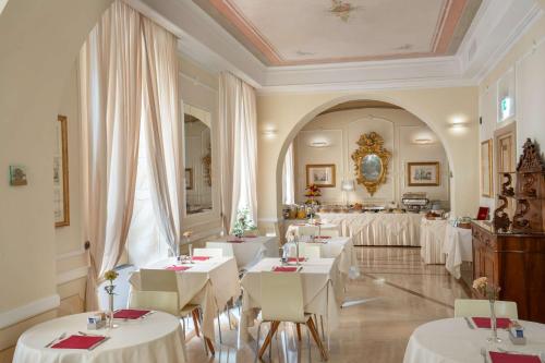 a restaurant with white tables and white chairs at Hotel Canada, BW Premier Collection in Rome