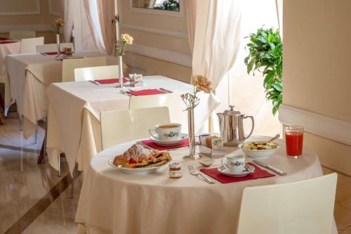 a table with a plate of food on it at Hotel Canada, BW Premier Collection in Rome