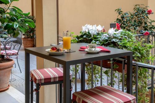 a table with a plate of food and a glass of orange juice at Hotel Canada, BW Premier Collection in Rome