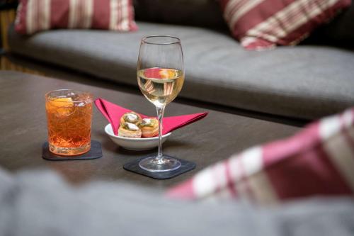 a glass of wine and a bowl of food on a table at Hotel Canada, BW Premier Collection in Rome