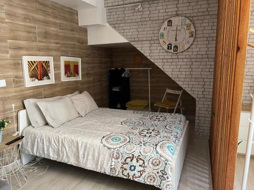 - une chambre dotée d'un lit avec une horloge murale dans l'établissement Casinha de São Pedro, à Peniche