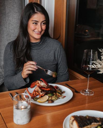 a woman sitting at a table with a plate of food at Nita Lake Lodge in Whistler