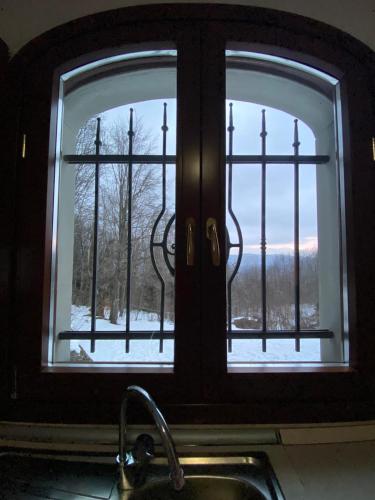 a kitchen window with a view of a snow covered yard at Villa Natale in Sestola
