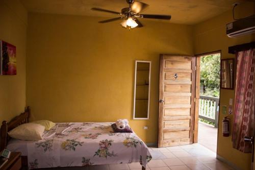 un dormitorio con una cama con un osito de peluche sentado en ella en Hilltop Horizon Guesthouse en San Ignacio