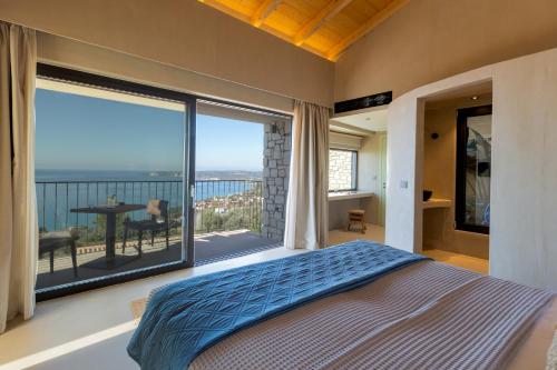 a bedroom with a large window with a view of the ocean at Apeiron Villas in Kefallonia
