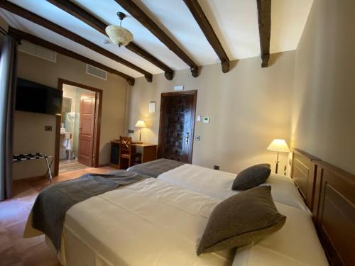 a bedroom with a large bed with pillows on it at Hotel Rural El Lagar de Nemesio in Perales de Tajuña