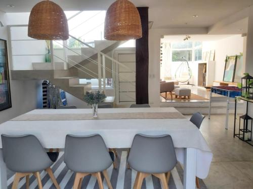 comedor con mesa blanca y sillas en Casa La Marejada en Balneario Mar Azul