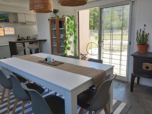 a kitchen with a white table and chairs in a room at Casa La Marejada in Mar Azul