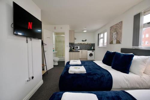 a hotel room with a large bed and a bathroom at Swan Studio Eight - Coventry in Coventry