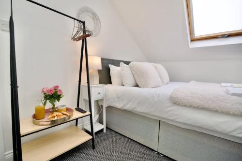 ein Schlafzimmer mit einem Bett und einem Tisch mit einer Lampe in der Unterkunft Swan Studio Nine - Coventry in Coventry