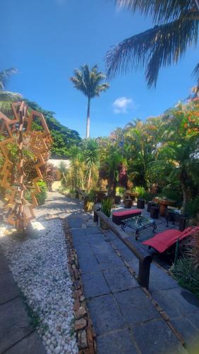 a park with benches and a palm tree in the background at 3 Palmeiras Guest Lounge in Miguel Pereira