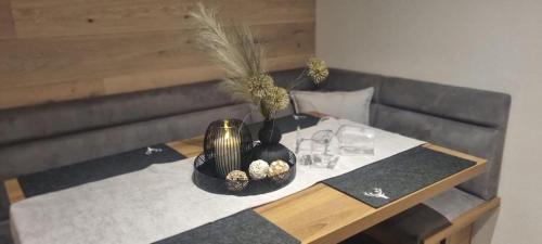 een tafel met een vaas en glazen erop bij Appartement Krismer in Fügen