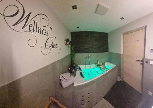 een badkamer met een bad en een wastafel met de woorden wellnessclub bij Appartement Krismer in Fügen